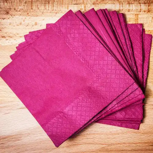 Stos magenta serwetek papierowych z wzorem w diamenty.